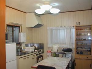 una cucina con un frigorifero bianco e un tavolo con sedie di Cottage Karuizawa a Karuizawa Altre 44 foto