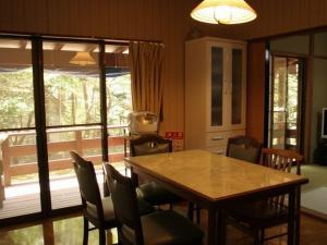 una sala da pranzo con tavolo e sedie in legno di Cottage Karuizawa a Karuizawa