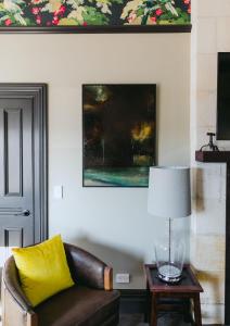 a living room with a couch and a table with a lamp at The Old Confectionery in Oamaru