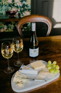 a table with a bottle of wine and two glasses at The Old Confectionery in Oamaru