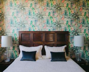 a bedroom with a bed with a floral wallpaper at The Old Confectionery in Oamaru