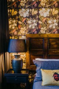 a bedroom with a bed with a flower wallpaper at The Old Confectionery in Oamaru