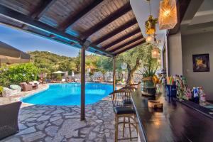 a swimming pool with a table and chairs next to it at MEGA AMMOS HOTEL in Syvota