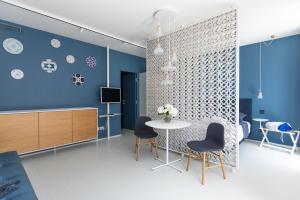 a living room with blue walls and a table and chairs at Santa Caterina - Dimora sul mare in Polignano a Mare