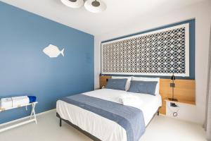 een slaapkamer met een bed met blauwe muren en een raam bij Santa Caterina - Dimora sul mare in Polignano a Mare