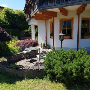 einen Tisch und einen Stuhl vor einem Haus in der Unterkunft Ferienwohnung Alpenrose in Goldegg