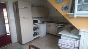 a small kitchen with white cabinets and a staircase at Kummerower See in Dargun