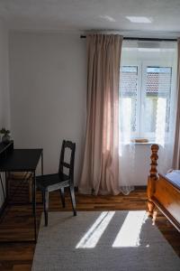 1 dormitorio con escritorio, silla y ventana en Apartment Danielsbergblick, en Napplach