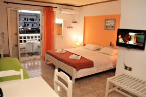 1 dormitorio con 1 cama y TV en una habitación en Aris Studios, en Hersonissos