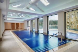a swimming pool with a blue floor and windows at Ensana Buxton Crescent in Buxton