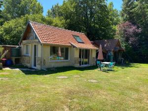 uma pequena casa com um telhado vermelho num quintal em Ad libitum em Les Ageux