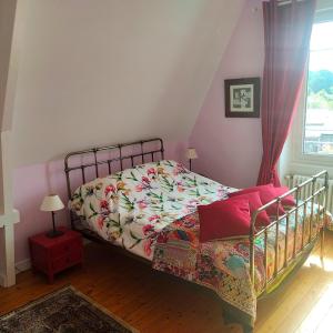 um quarto com uma cama com um edredão colorido e uma janela em Le Clos Saint-Brice em Les Portes du Coglais