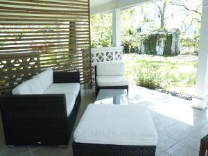 a porch with two white chairs and a table at Rainbow House and small garden in Princeton