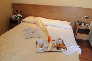 uma bandeja de alimentos de pequeno-almoço numa cama em Hotel Ristorante La Lanterna em Villaricca