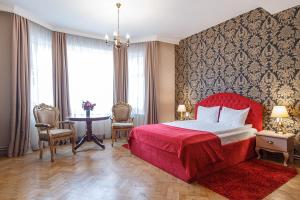 a bedroom with a red bed and a table with chairs at Casa Monte Verde in Braşov