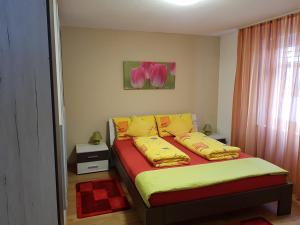 - une chambre dotée d'un lit avec des draps jaunes et rouges dans l'établissement Casa Mila, à Muotathal