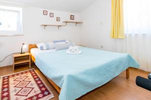 sypialnia z łóżkiem z niebieskim kocem w obiekcie Cozy apartments Emina near the sea w mieście Premantura