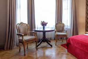 a room with a table and two chairs and a bed at Casa Monte Verde in Braşov