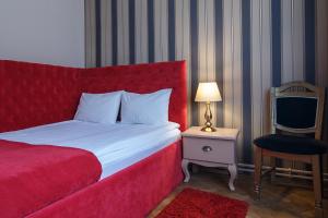 una camera con letto rosso e sedia di Casa Monte Verde a Braşov