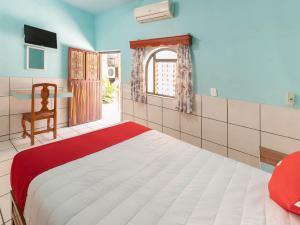 - une chambre avec un grand lit et une fenêtre dans l'établissement Hotel Posada Agua Escondida, à Cihuatlán