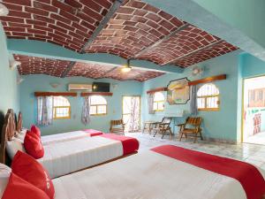 a bedroom with two beds in a room at Hotel Posada Agua Escondida in Cihuatlán