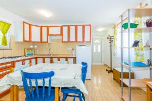 kuchnia ze stołem i 2 niebieskimi krzesłami w obiekcie Cozy apartments Emina near the sea w mieście Premantura