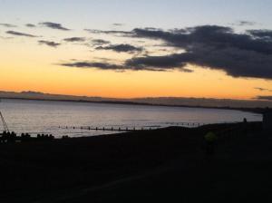a sunset over a beach with a body of water at Navigator Hotel in Bognor Regis +1 photo