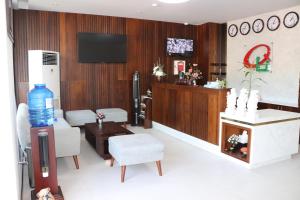 een wachtkamer met stoelen en een tv en een tafel bij Qli Hotel in Mũi Né