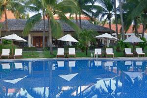 a swimming pool with chairs and umbrellas in front of a resort at Blue Ocean Resort in Mui Ne +99 photos