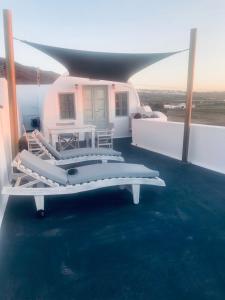a white couch sitting under an umbrella on a patio at Vrachia Studios & Apartments in Oia
