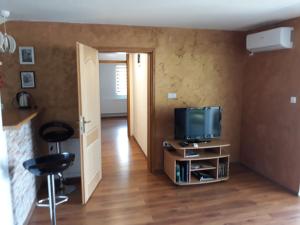 a room with a television and two stools at Apartman Dan & Noc in Višegrad