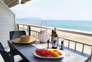 a table with a plate of fruit and a bottle of wine at House Kohili in Nea Vrasna