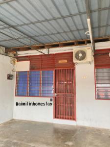 een gebouw met een rode deur en een ventilator bij Aimilin Homestay in Kampong Ibus