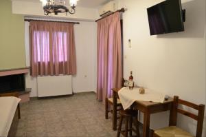 a room with a table and chairs and a window at Tsonos Apartments in Keramídhion