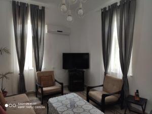 uma sala de estar com 2 cadeiras e uma televisão de ecrã plano em Mul Hayar em Bet Leẖem HaGelilit