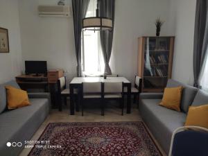 un soggiorno con 2 divani, un tavolo e una scrivania di Mul Hayar a Betlemme di Galilea