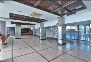 einer Lobby eines Gebäudes mit Säulen und Fenstern in der Unterkunft Hotel Kohinoor in Bharūch