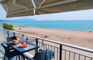 a table on a balcony with a view of the beach at House Kohili in Nea Vrasna