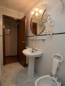W łazience znajduje się umywalka, lustro i toaleta. w obiekcie Hotel Odon w mieście Cocentaina