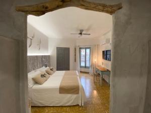 a bedroom with a white bed and a desk at Can Massana in Pau
