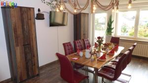 a dining room with a wooden table and red chairs at Ferienwohnung Jungle Adventure in Günzburg