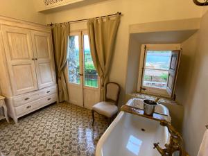 een badkamer met een bad, een wastafel en een raam bij Can Massana in Pau