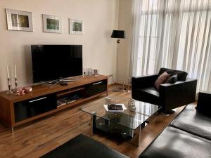 a living room with a couch and a television at Faupel Ferienwohnung in Mülverstedt