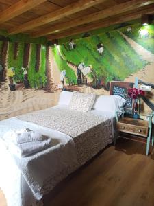 a bedroom with a bed and a wall with a mural at Casa Rural La Bodega in Aldeadávila de la Ribera