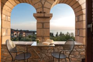 a patio with two chairs and a table with a book at Kalamitsi Hotel in Kardamyli