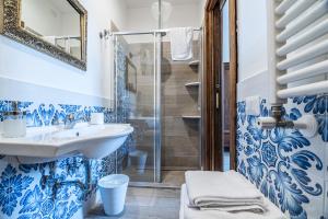 マッサ・ルブレンセにあるAgriturismo Il Giardino di Viglianoの青と白のバスルーム(シンク、シャワー付)