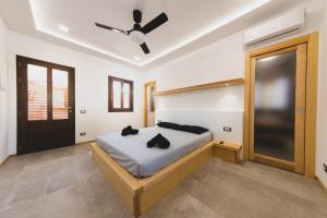 a bedroom with a bed and a ceiling fan at Residence Cala Grande in Cefalù