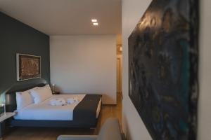a hotel room with a bed and a painting on the wall at Sicilia's Art Hotel & Spa in Acitrezza