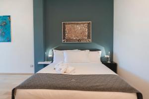 a bedroom with a large bed with a blue wall at Sicilia's Art Hotel & Spa in Acitrezza