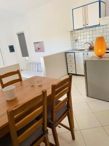 a kitchen with a wooden table and two chairs at Spanos Apartments in Agios Petros